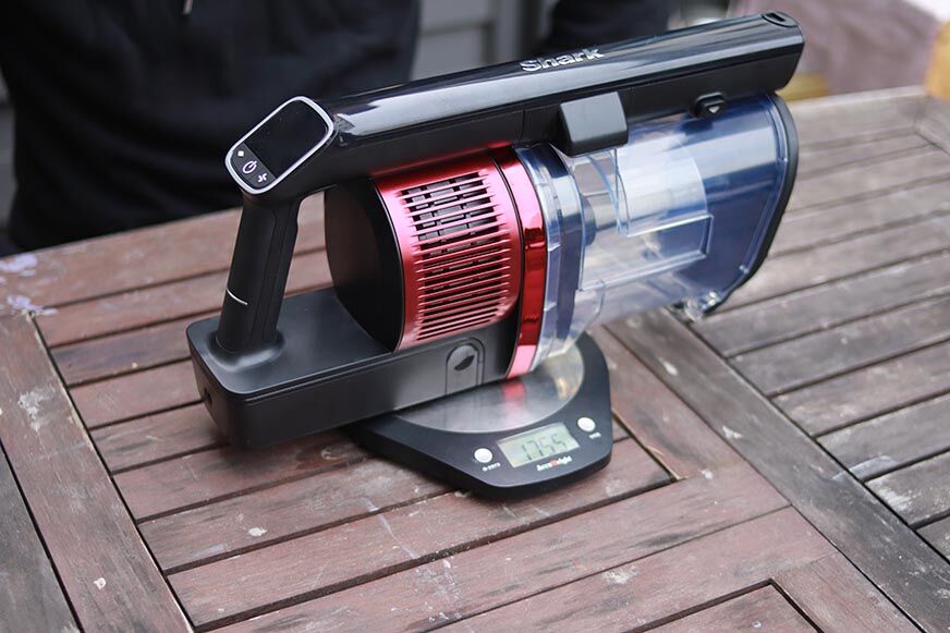 Man sieht, wie die Motoreinheit des Shark Anti Hair Wrap Flexology gewogen wird. 